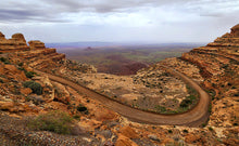 Load image into Gallery viewer, The Moqui Dugway was blasted into the towering cliffs of Cedar Mesa. It climbs 1,200 ft in just 3 miles to reveal some of the best views in the Southwest.
