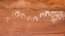 Load image into Gallery viewer, These handprints were created almost 1,000 years ago by blowing a mouthful of paint over the hand. This was most likely part of a puberty ceremony for young men. 
